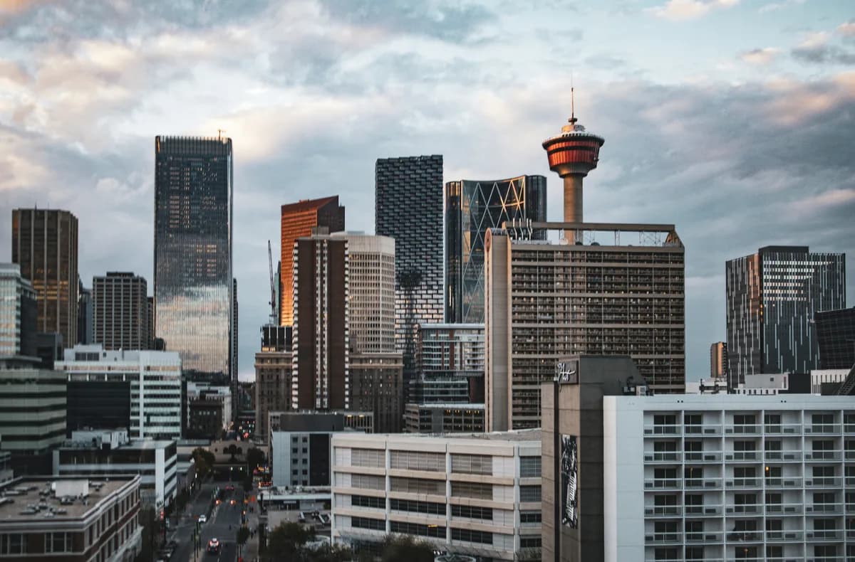 Calgary skyline and tower glowing above Beltline high-rises at dusk